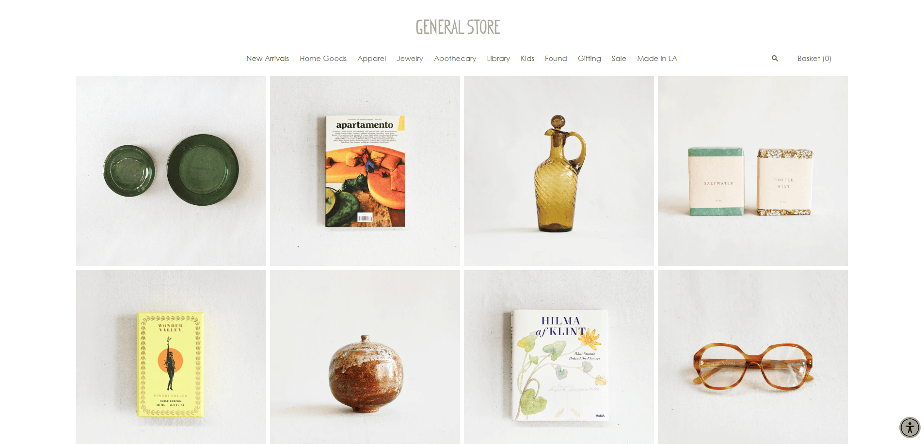 A minimalist artisan website displays eight items: green bowls, a lifestyle magazine, an amber glass bottle, two soap bars, a yellow journal, a ceramic vase, a floral book, and brown glasses. Perfect inspiration for artisan website design.
