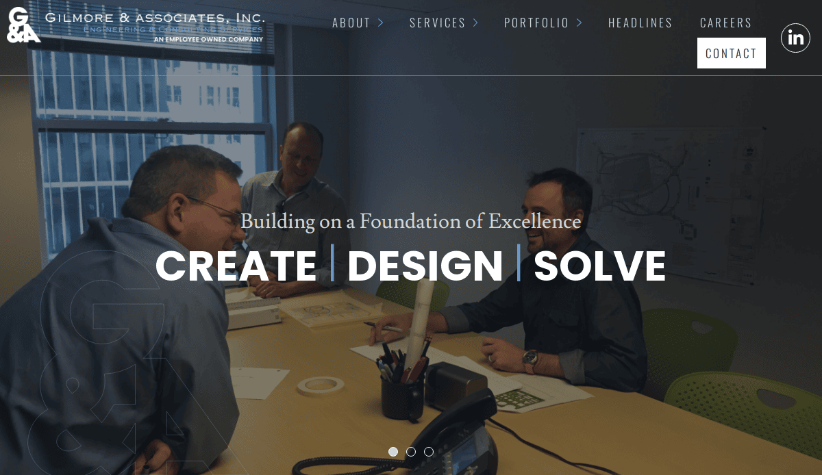 Three men are gathered around a conference table in a modern office, smiling and discussing documents. The text overlay reads, CREATE | DESIGN | SOLVE – Building on a Foundation of Excellence in civil engineering website design.