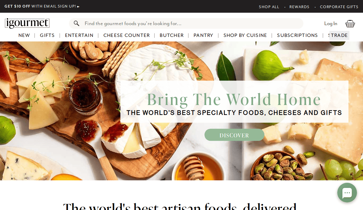 A platter of assorted cheeses, figs, nuts, crackers, and bread is displayed on a wooden board. Text reads: Bring The World Home—Discover the world’s best specialty foods and gifts on our artisan website.