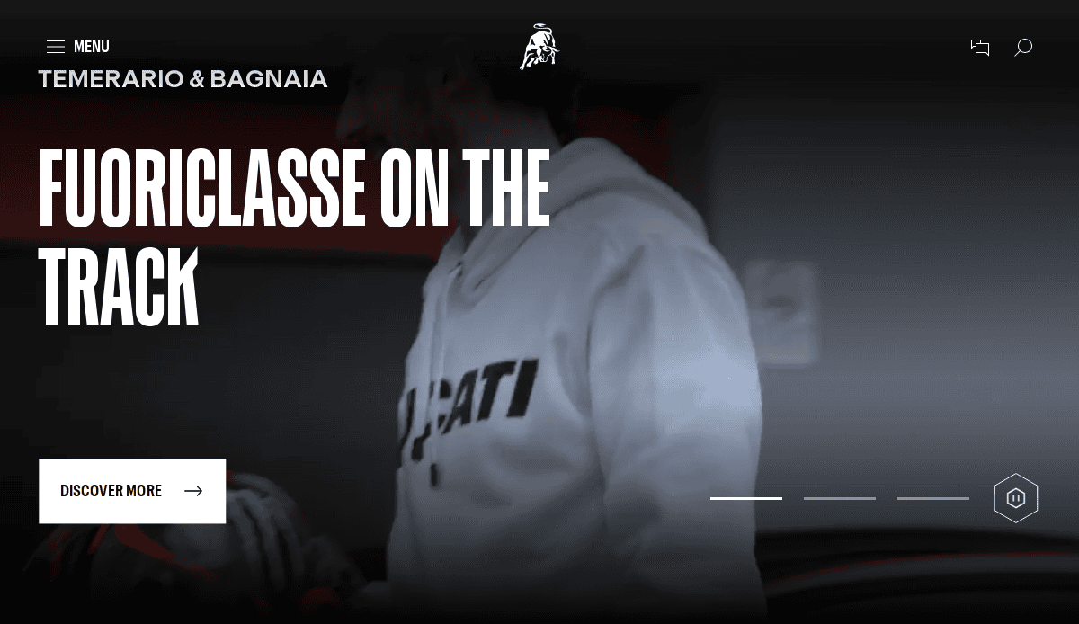 A person wearing a white Ducati hoodie stands indoors, partially facing left. Large text reads Fuoriclasse on the track. Perfect for drive traffic to your automotive website design. A button below says Discover more. The background is slightly blurred.