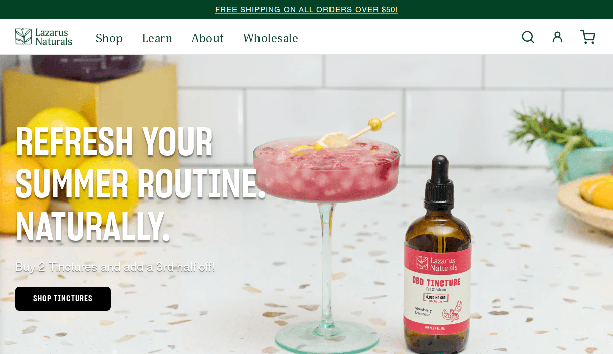 A pink summer drink with a skewer sits next to a Lazarus Naturals CBD tincture bottle on a countertop. Text reads, Refresh your summer routine. Naturally—an inspiring scene for your CBD online store or CBD business brand.