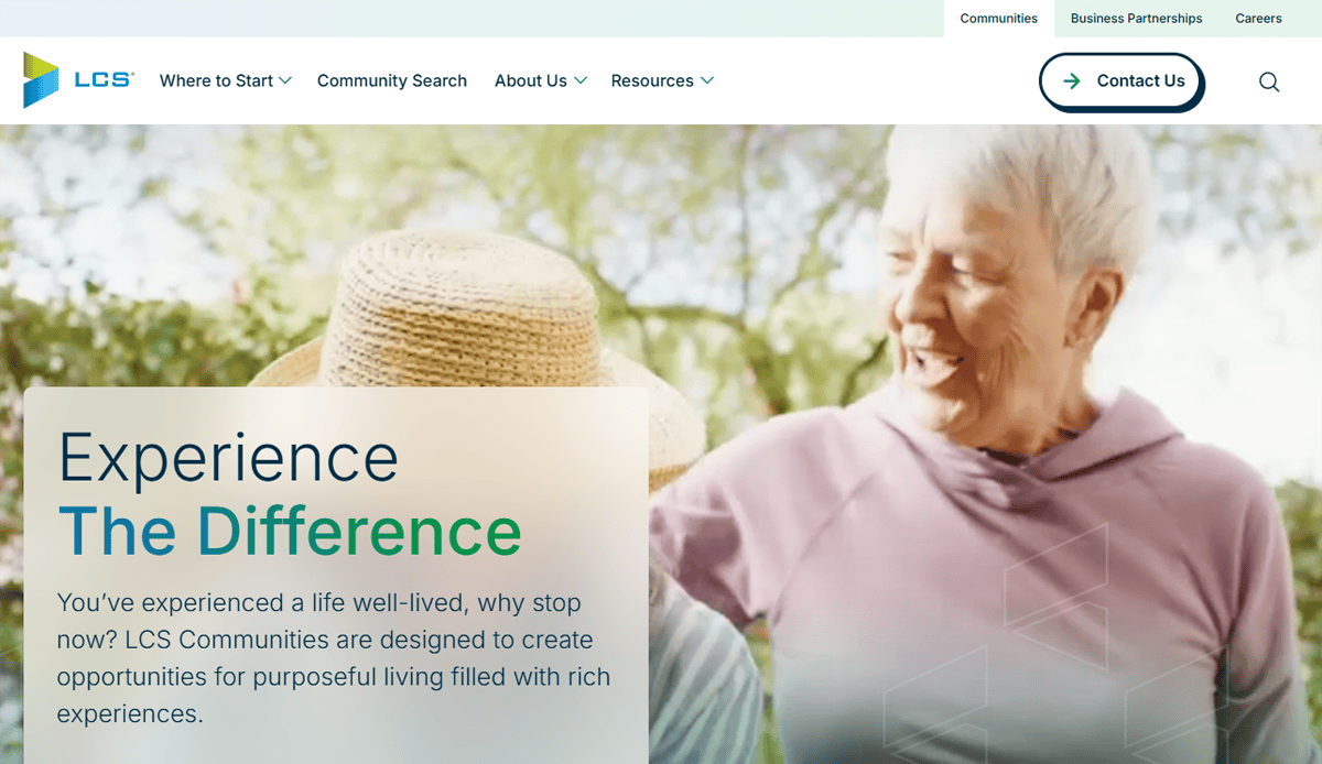 An older woman smiles and interacts outdoors with another person wearing a hat, as sunlight filters through trees. The text reads, “Experience The Difference,” highlighting the benefits of an engaging Assisted Living Website for LCS Communities.