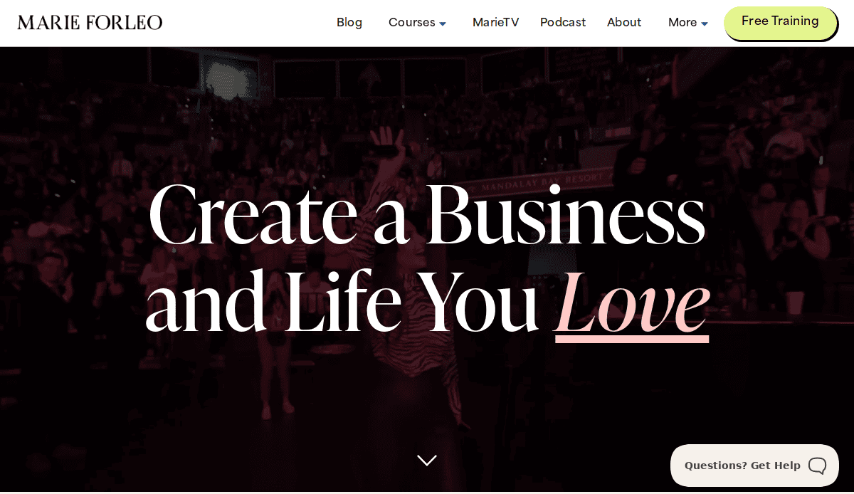 A website homepage with the headline “Create a Business and Life You Love” over a photo of a cheering audience, helping you build a coaching website with menu links and a yellow “Free Training” button at the top right.