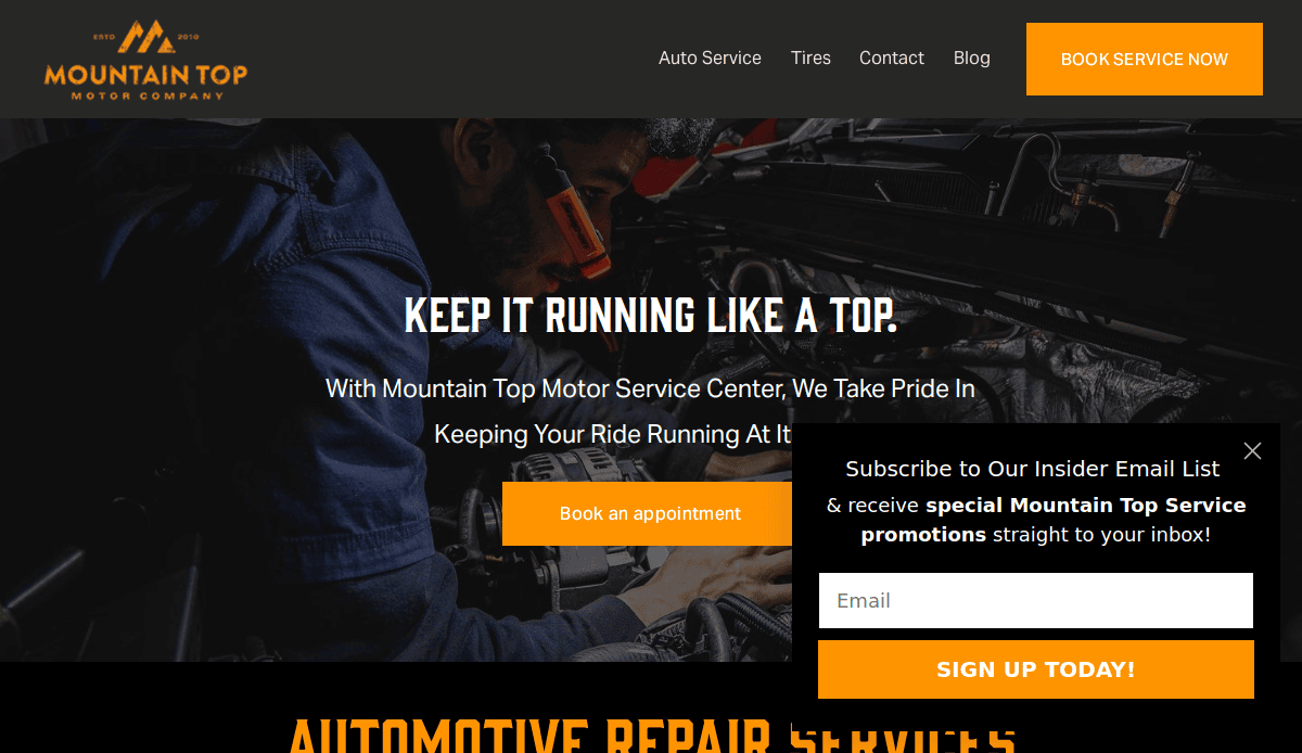 A mechanic wearing safety glasses works under the hood of a car. The banner reads Keep It Running Like a Top for Mountain Top Motor Company, showcasing a car mechanic website design to boost online bookings and promote service specials via email.