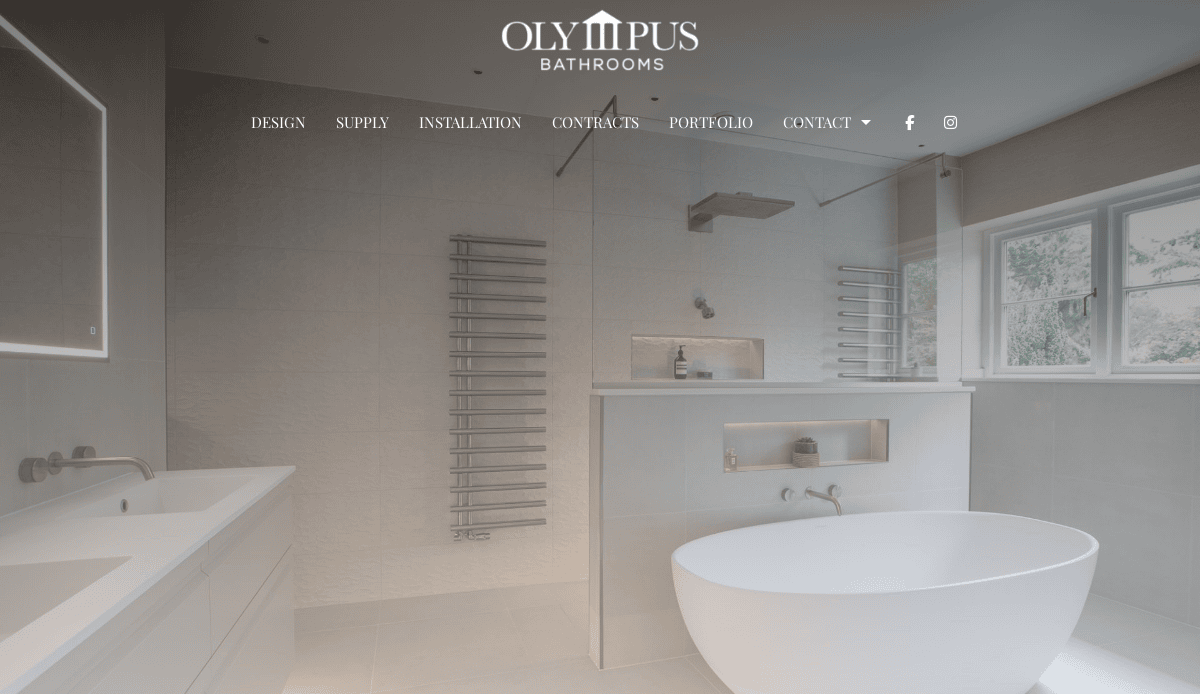 Modern bathroom with a freestanding white bathtub, wall-mounted sink, heated towel racks, glass shower enclosure, and large window. Olympus Bathrooms logo and menu showcase expert bathroom remodeling and website design to convert visitors into clients.