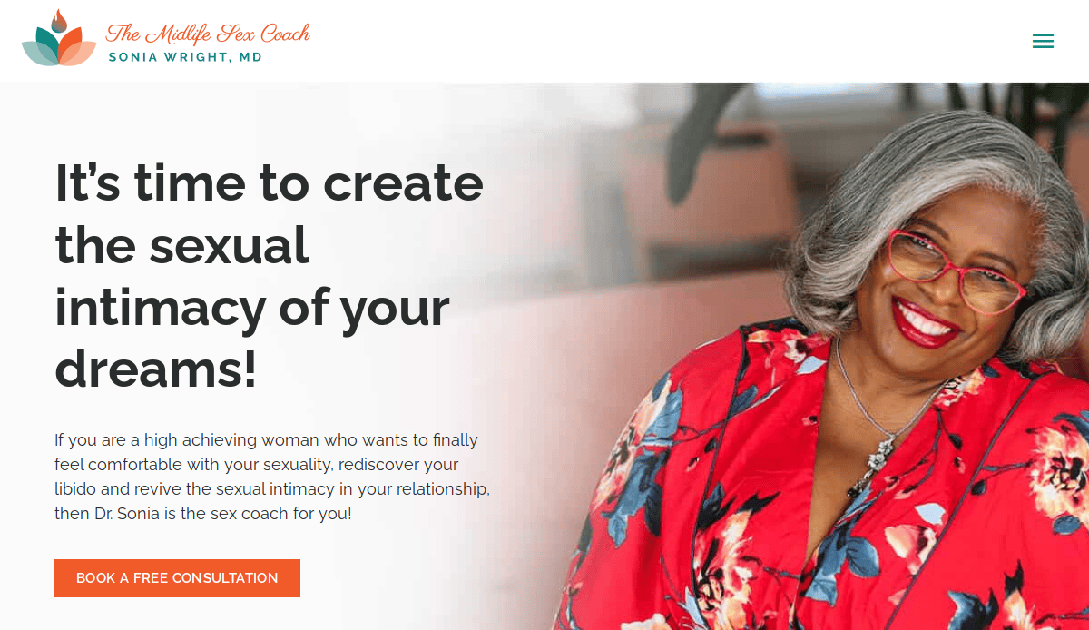A smiling woman with gray hair and glasses, in a vibrant red floral dress, sits on a beige couch. Beside her, text reads: It's time to create the sexual intimacy of your dreams! Plan with purpose on our coaching website—book your free consultation today.