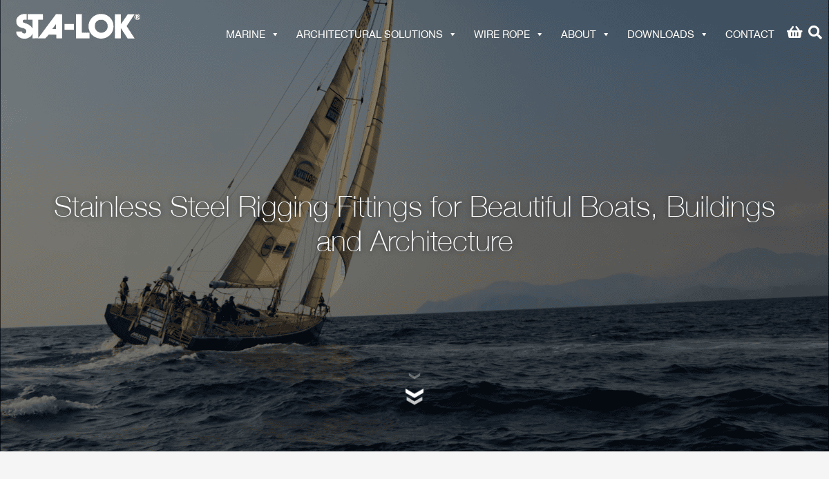 A sailboat with several people aboard sails on the open sea, leaning to one side, with mountains in the background under a clear sky. STA-LOK branding and website design navigation are overlaid at the top.