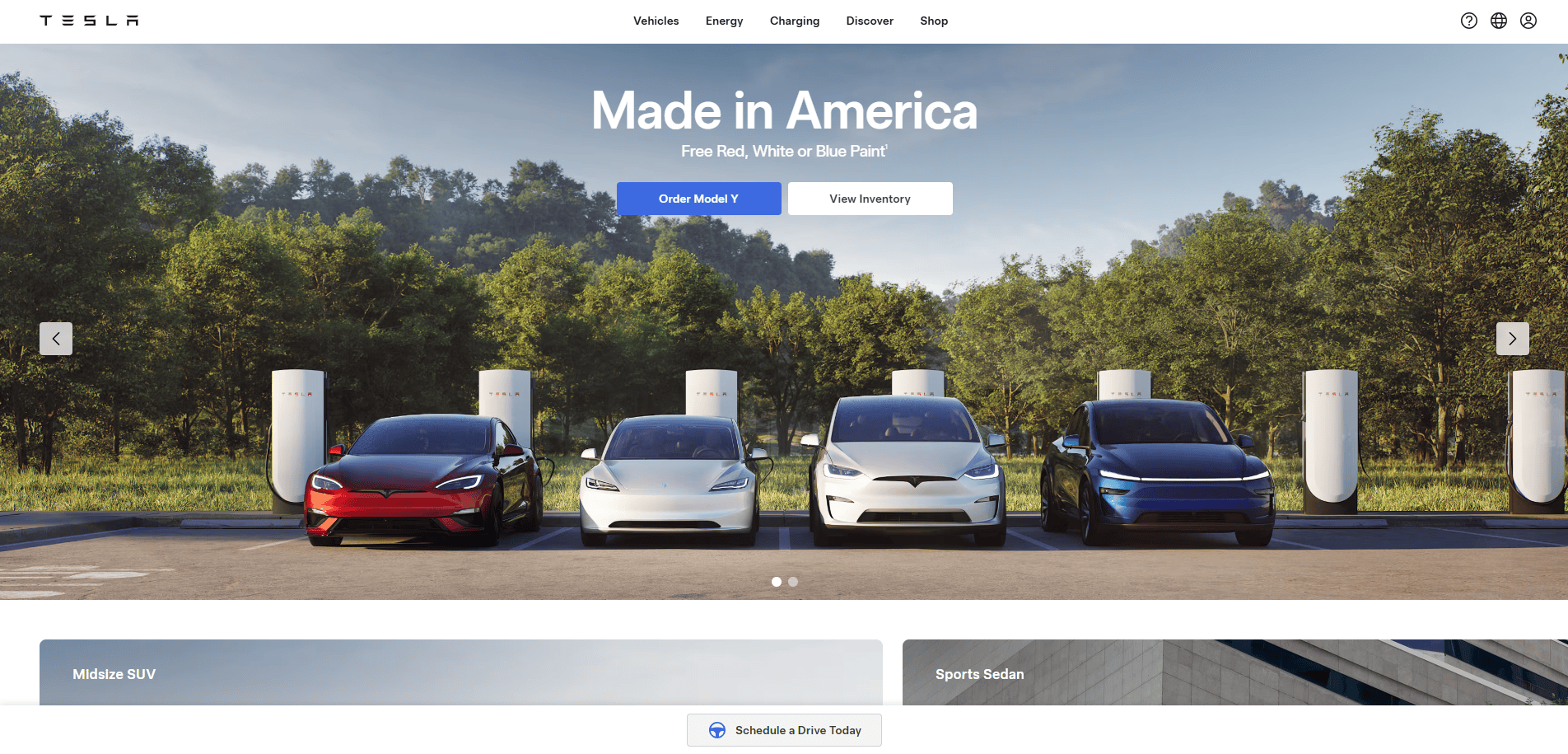 Four Tesla electric vehicles in red, black, white, and blue are parked at charging stations outdoors with trees in the background. Showcasing expert automotive website design, the text reads Made in America with options to order or view inventory.