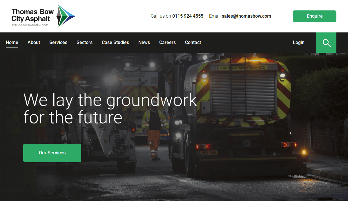 A nighttime roadwork scene with an asphalt contractors vehicle and workers in high-visibility clothing. The Thomas Bow City Asphalt logo and navigation menu appear at the top, with a banner reading We lay the groundwork for the future.