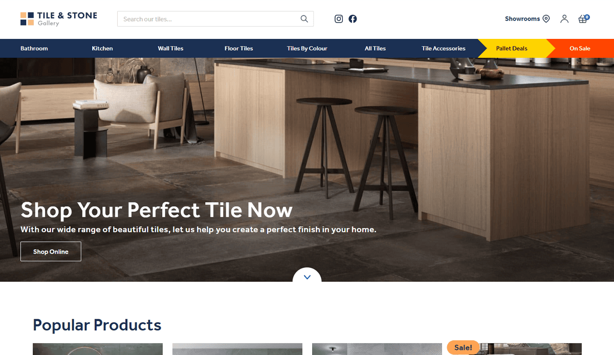 Modern kitchen showroom with a wood island, two barstools, tile flooring, and stylish decor. Website banner highlights performance tile selection and deals, with navigation menus and a “Shop Your Perfect Tile Now” message for lead generation.