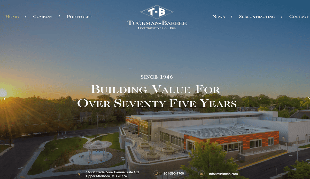 Aerial view of a modern building at sunset with Tuckman-Barbee Construction Co., Inc. logo and contact info. Text reads: “Building Value For Over Seventy Five Years. Since 1946.” Navigation links highlight commercial construction expertise.