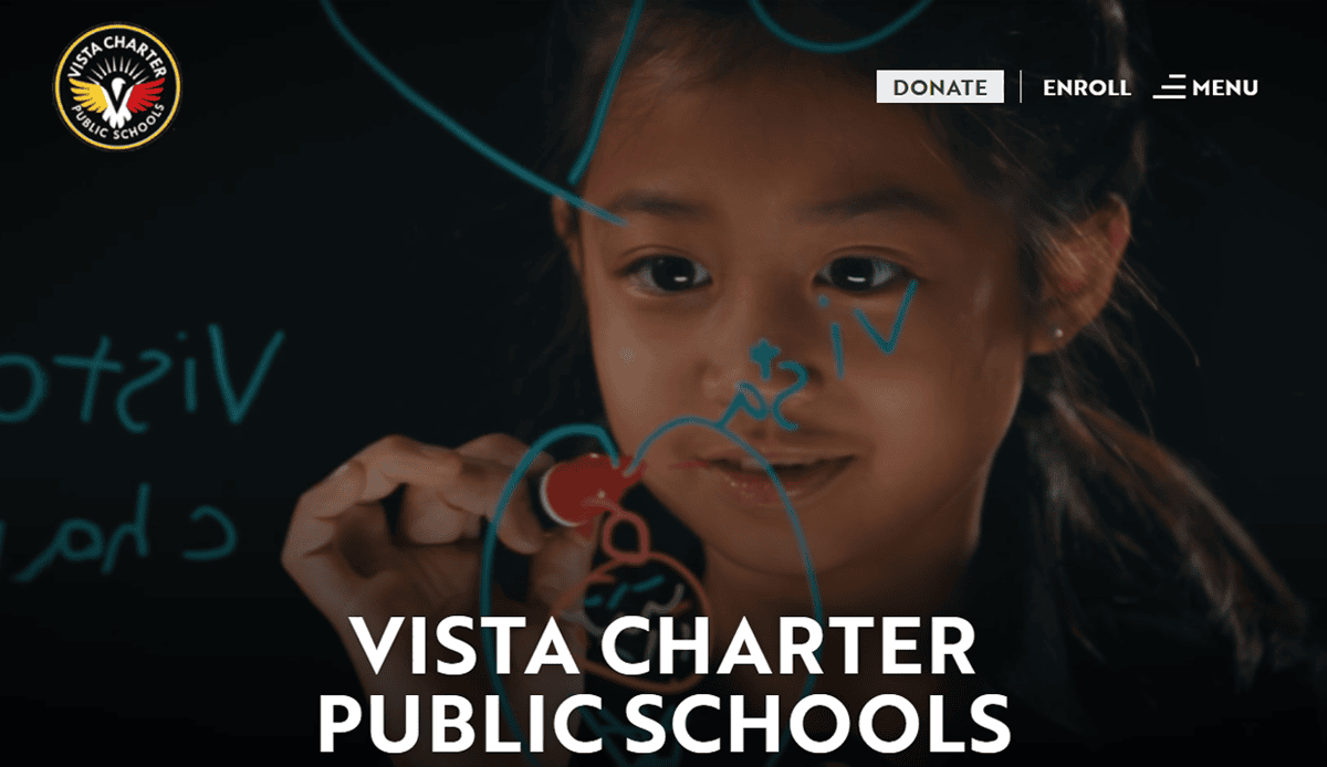 A young girl writes with a blue marker on a transparent board. The Vista Charter Public Schools logo is in the top left, and buttons for Donate, Enroll, and Menu at the top showcase a best school website design. The text reads VISTA CHARTER PUBLIC SCHOOLS.
