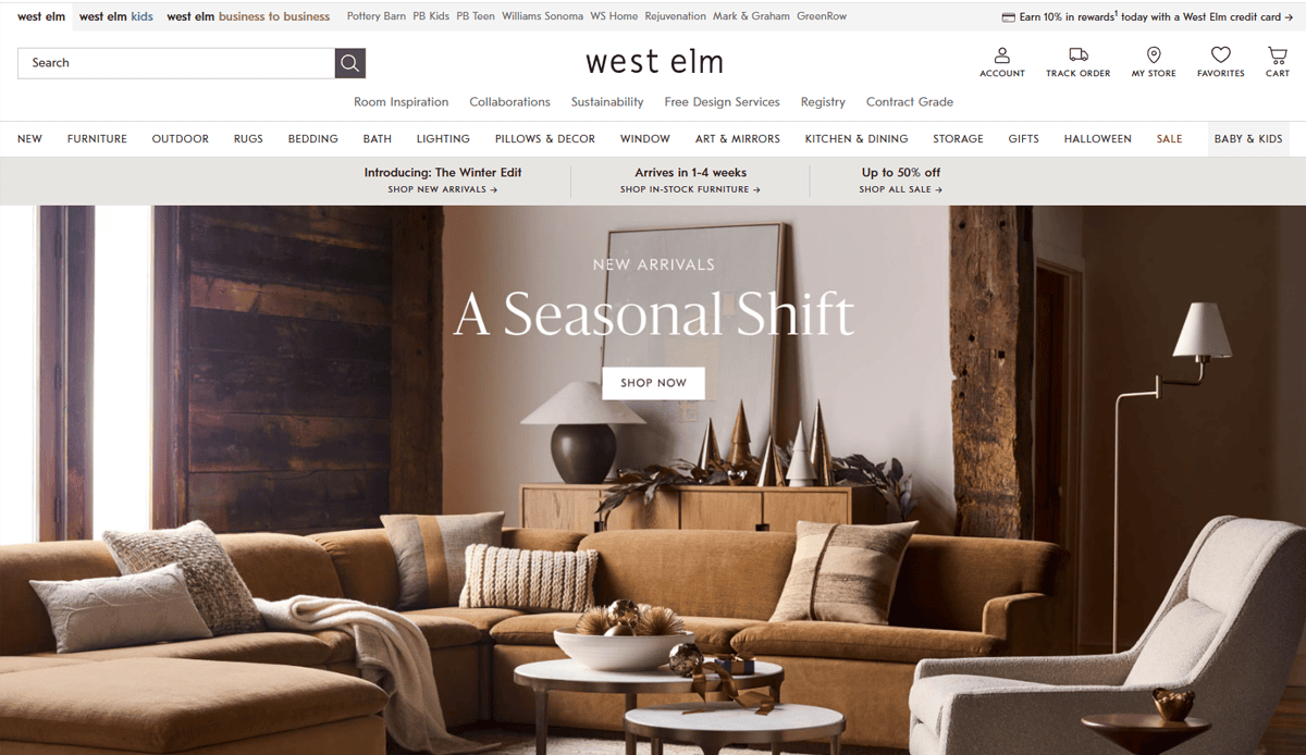 A modern living room with neutral-toned sofas, round coffee tables, gold decor accents, and large windows with brown curtains, showcased on a stylish furniture website design for West Elm’s homepage promoting new seasonal arrivals.