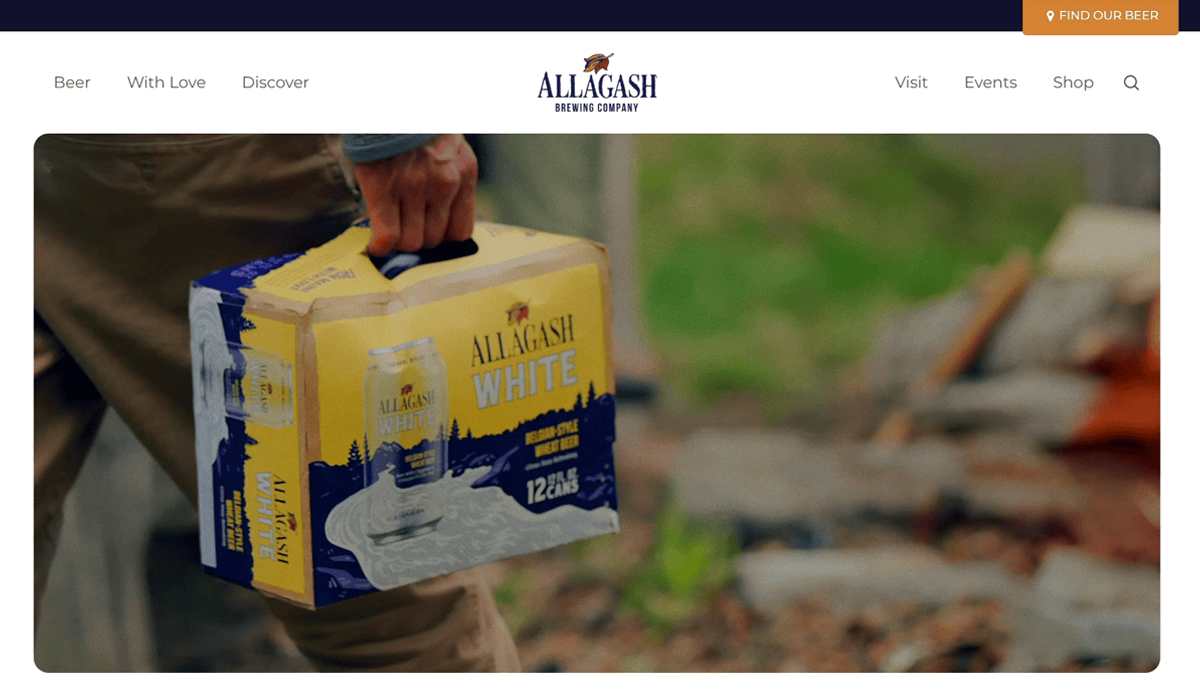A person carries a 12-pack of Allagash White beer outdoors, set against a blurred natural background. The Allagash Brewing Company logo tops the brewery website design, reflecting modern design trends.