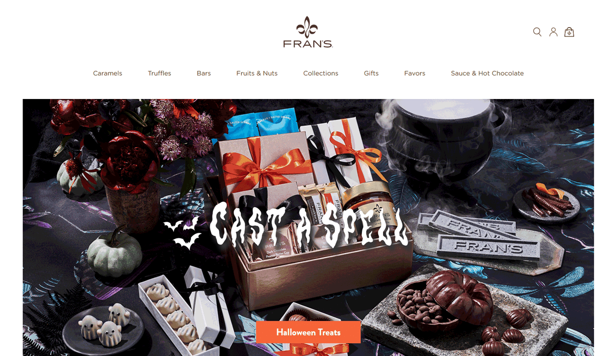 A festive display of assorted chocolates and candies in elegant boxes, surrounded by decorative pumpkins and smoky effects, with Cast A Spell written over the image. The candy website design features a visible menu and a Halloween Treats button.