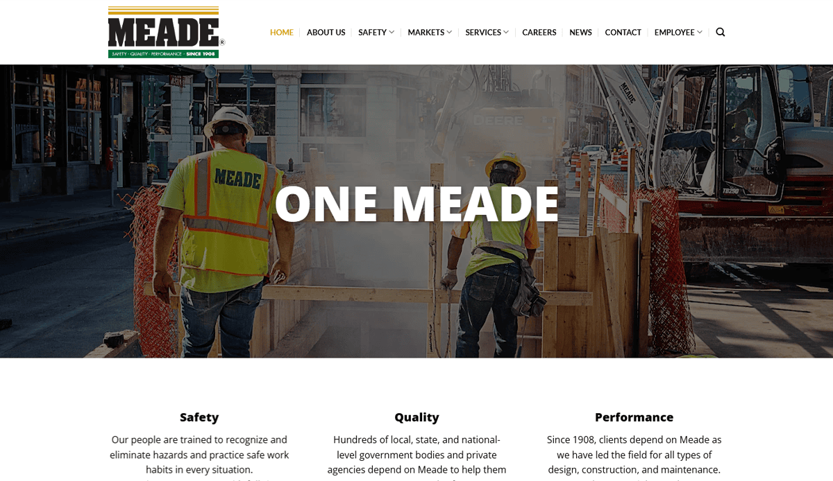 Two construction workers, one in a MEADE safety vest, stand at an urban construction site. "ONE MEADE" is centered on the image, highlighting their expertise as a commercial electrician. The website design’s navigation menu is visible at the top.