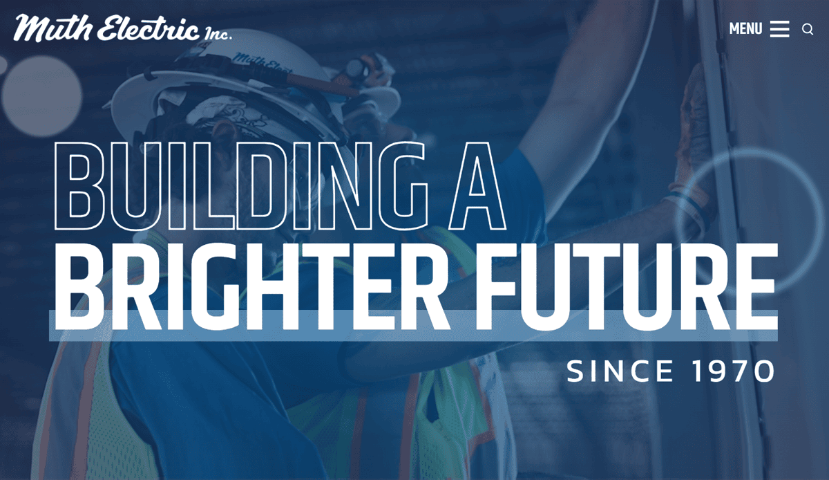 A commercial electrician in a hard hat and safety gear works on an electrical panel with the text “BUILDING A BRIGHTER FUTURE SINCE 1970” and the logo “Muth Electric Inc.”—perfect for a site that converts.