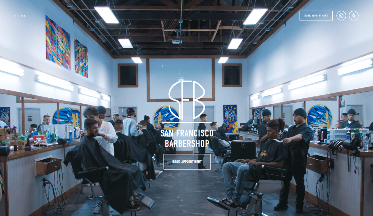 A modern barbershop with several barbers cutting clients’ hair in a well-lit space featuring large mirrors, exposed ceiling beams, and a central logo reading “San Francisco Barbershop”—a showcase of sleek barber shop design.