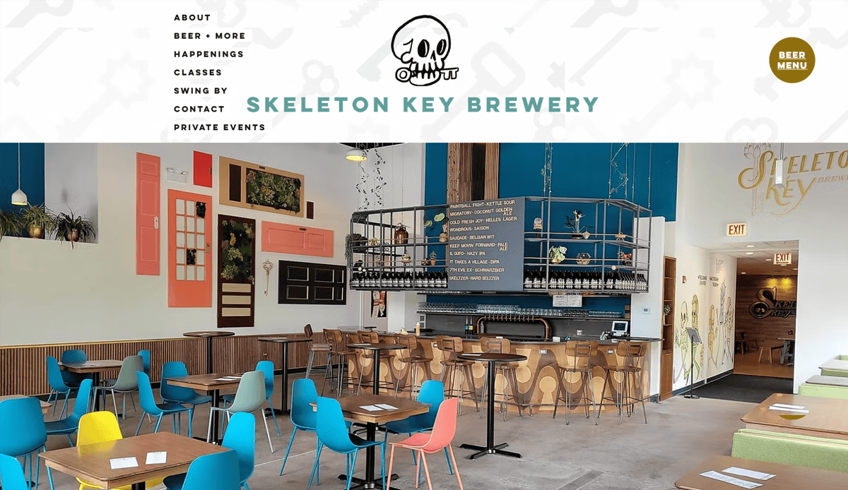 A bright, modern brewery taproom with colorful chairs, wooden tables, quirky wall art, and a Skeleton Key Brewery sign showcases design trends perfect for any brewery website design. The space appears clean and inviting.